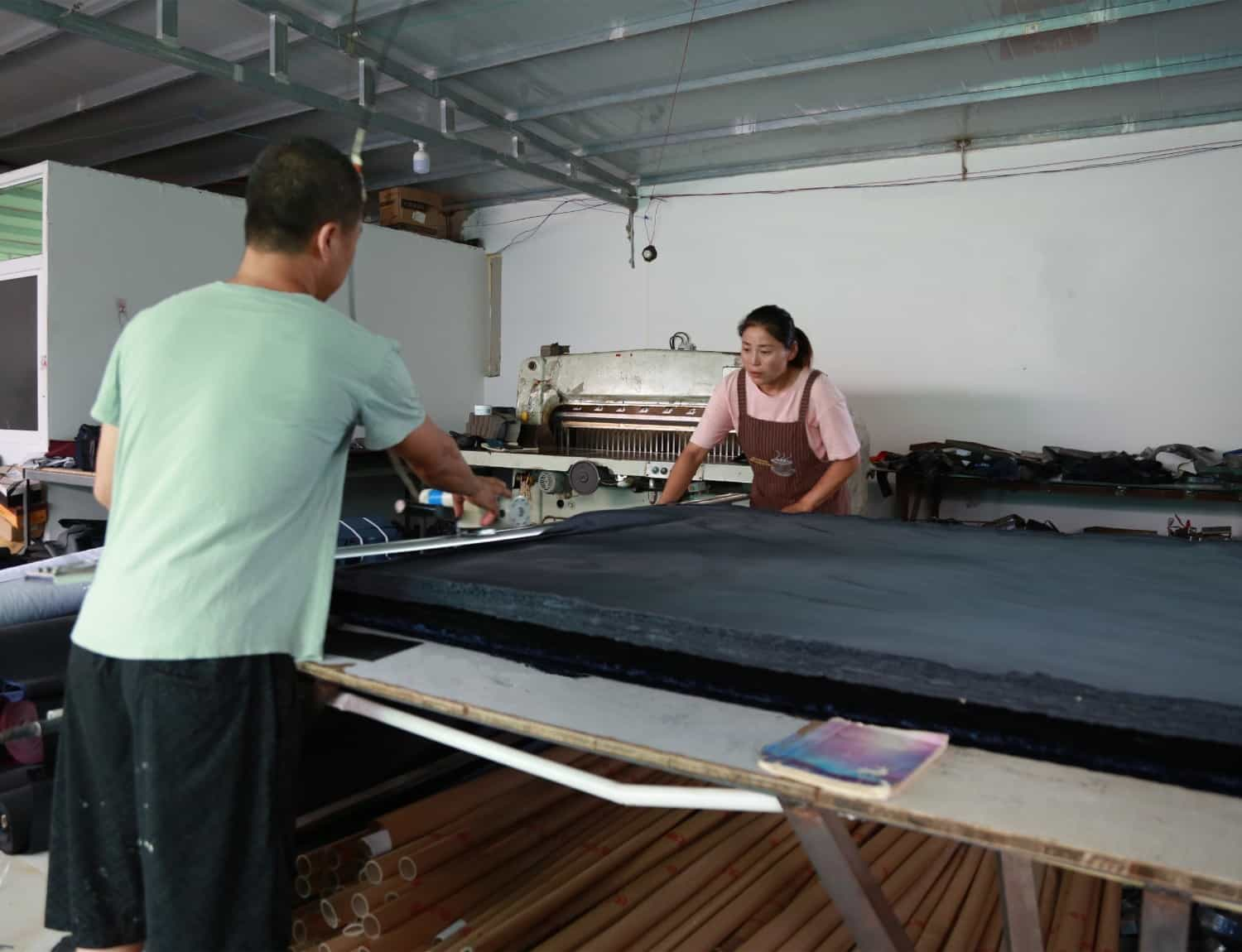 Wang Rui and his wife from Wanglangou Village are cutting fabrics